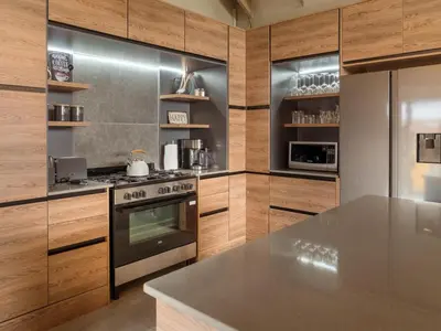 a kitchen with stainless steel appliances and wooden cabinets at Highland Gate Dullstroom by Cloete's Nest in Dullstroom
