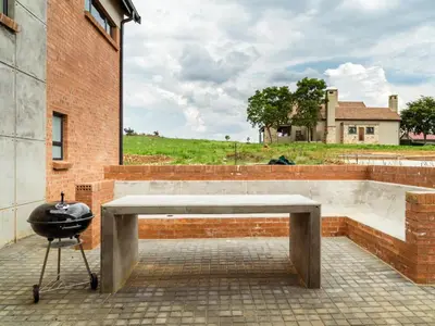 a barbecue grill sitting next to a brick building at Highland Gate Dullstroom by Cloete's Nest in Dullstroom