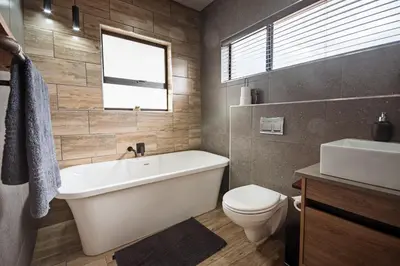 a bathroom with a tub and a toilet and a sink at Highland Gate Dullstroom by Cloete's Nest in Dullstroom