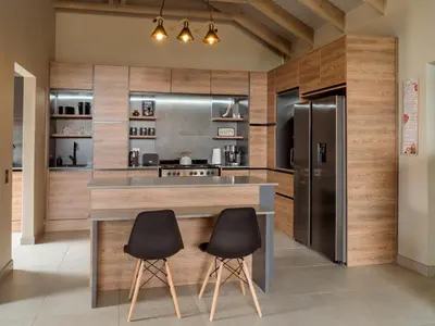 a kitchen with a counter with two chairs and a refrigerator at Highland Gate Dullstroom by Cloete's Nest in Dullstroom