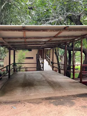 a wooden bridge with a building and trees in the background at Blyde River Self-Catering Studios in Hoedspruit