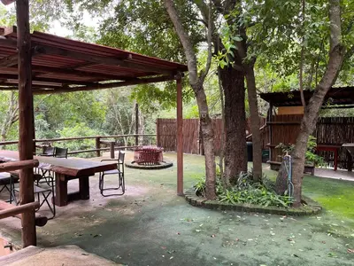 a picnic shelter with a picnic table and trees at Blyde River Self-Catering Studios in Hoedspruit