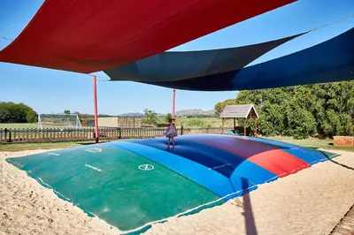 a person standing on top of a large parachute at First Group Magalies Park in Hartbeespoort