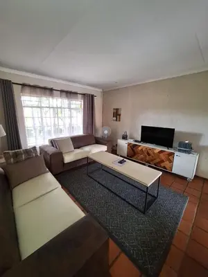 a living room with a couch and a tv at Die Eend in Centurion