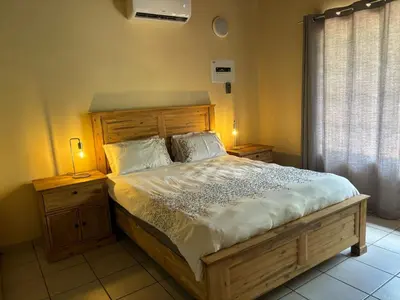 a bedroom with a large wooden bed with two lamps at Le Lion Dort in Marloth Park