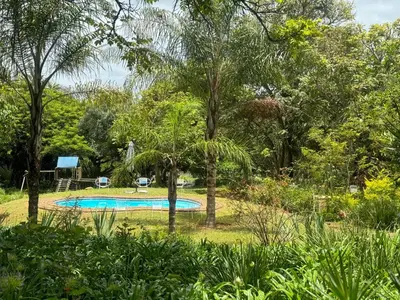 a swimming pool in the middle of a garden at Busa House in White River