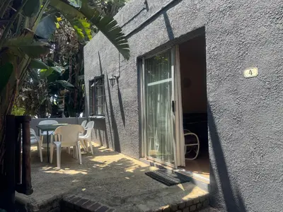 a patio with a table and chairs next to a building at Busa House in White River