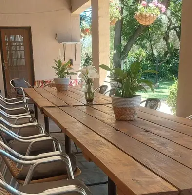 a long wooden table with chairs and plants on it at Blossom Retreat at Ilnika Farm Stay in Naboomspruit