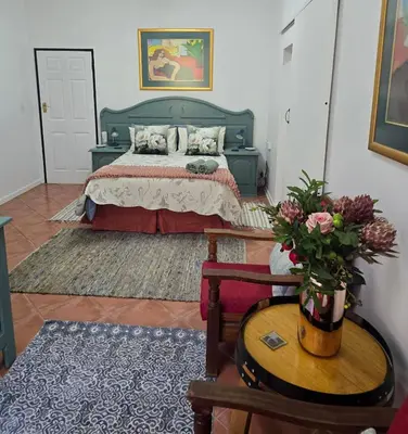 a bedroom with a bed and a table with a vase of flowers at Ilnika Farm Stay in Naboomspruit