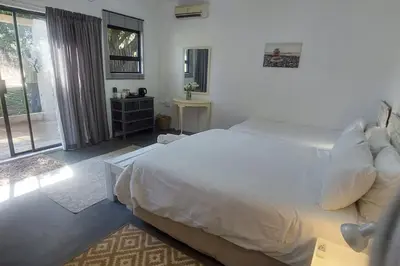 a bedroom with a large white bed and a window at Ilnika Farm Stay in Naboomspruit