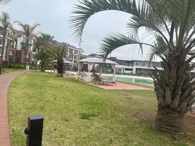 a palm tree in a park next to a building at The Blyde Crystal Lagoon in Pretoria