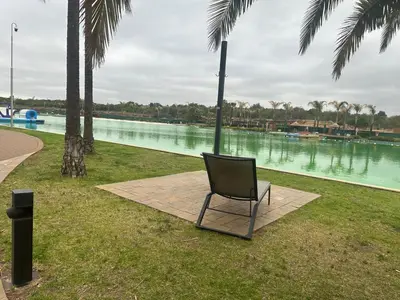 a chair sitting on the grass near a body of water at The Blyde Crystal Lagoon in Pretoria