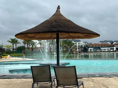 two chairs and an umbrella in front of a swimming pool at The Blyde Crystal Lagoon in Pretoria