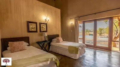 a bedroom with two beds and a window at Zebula Golf and Wildlife Estate - Porcupine Strolling Pax 8 - Moi Signature Luxury villa in Mabula