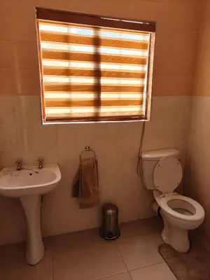 a bathroom with a toilet and a sink and a window at Unit 89 Pendleberry Holiday Resort in Bela-Bela