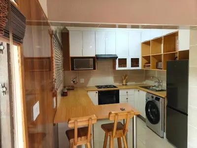 a small kitchen with a wooden table and two chairs at Unit 89 Pendleberry Holiday Resort in Bela-Bela