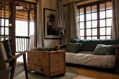 a living room with a couch and a coffee table at Amare Cabin in the bush with all your needs! in Marloth Park