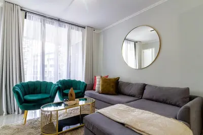 a living room with a couch and chairs and a mirror at #AlimamaSpaces: Jay's Cassini in Midrand