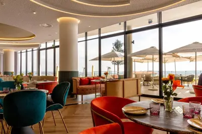 a restaurant with tables and chairs and large windows at #AlimamaSpaces: Jay's Cassini in Midrand