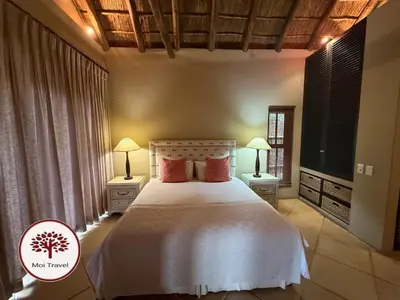 a bedroom with a bed with two lamps and a tv at Zebula Golf and Wildlife Estate - Nights Sky Pax 16 - Moi Signature Luxury villa in Mabula