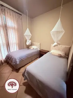 a bedroom with two beds and a window at Zebula Golf and Wildlife Estate - Nights Sky Pax 16 - Moi Signature Luxury villa in Mabula