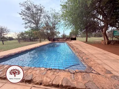 a large swimming pool in a field with trees at Zebula Golf and Wildlife Estate - Nights Sky Pax 16 - Moi Signature Luxury villa in Mabula