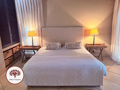 a bedroom with a large bed with two lamps at Zebula Golf and Wildlife Estate - Nights Sky Pax 16 - Moi Signature Luxury villa in Mabula