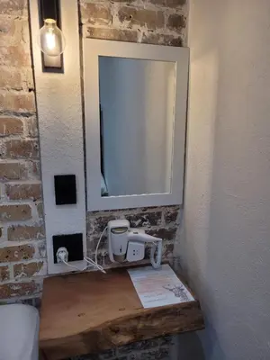 a mirror on a wall next to a table in a room at Nguni House in Mataffin