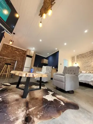 a room with a table and a couch and a bed at Nguni House in Mataffin