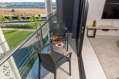 a balcony with two chairs and a table at Witshire Luxury apartment, Ellipse in Midrand