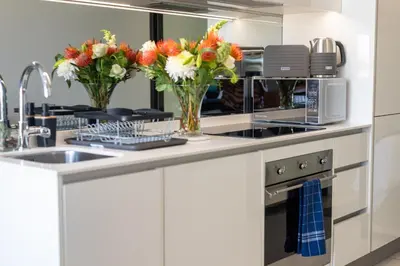 a kitchen with flowers in vases on a counter at Witshire Luxury apartment, Ellipse in Midrand