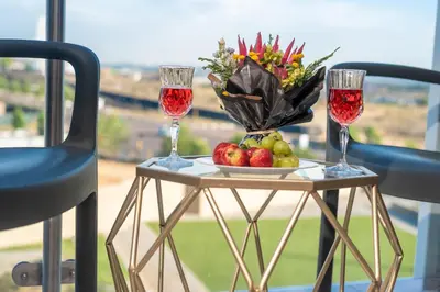a table with two glasses of wine and a plate of fruit at Witshire Luxury apartment, Ellipse in Midrand