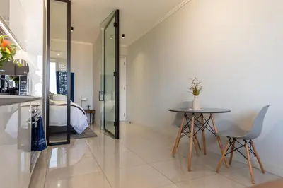 a room with a table and a bed and a table and chairs at Witshire Luxury apartment, Ellipse in Midrand