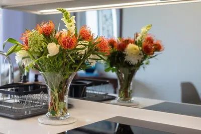 two vases filled with flowers sitting on a counter at Witshire Luxury apartment, Ellipse in Midrand