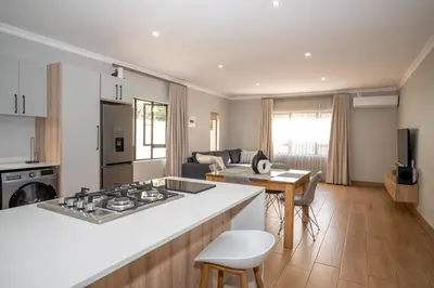 a kitchen and living room with a stove top oven at Utopia on the Rock2 in Nelspruit