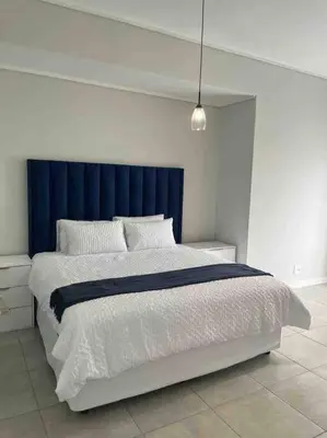 a bedroom with a large bed with a blue headboard at Executive Penthouse in Midrand, Waterfall City - Fast WiFI and Secure Parking - 3 Elizabeth Place in Midrand