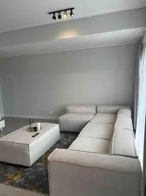 a living room with a white couch and a table at Executive Penthouse in Midrand, Waterfall City - Fast WiFI and Secure Parking - 3 Elizabeth Place in Midrand