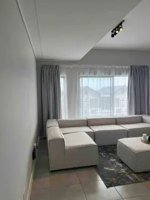 a living room with a couch and a window at Executive Penthouse in Midrand, Waterfall City - Fast WiFI and Secure Parking - 3 Elizabeth Place in Midrand