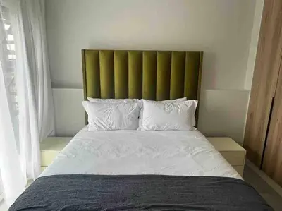 a bedroom with a large bed with a green headboard at Executive Penthouse in Midrand, Waterfall City - Fast WiFI and Secure Parking - 3 Elizabeth Place in Midrand