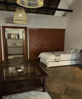 a bedroom with a bed and a coffee table at Halali Wilderness Private Game Ranch in Hammanskraal