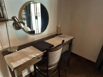 a desk with a mirror and a table with chairs at Halali Wilderness Private Game Ranch in Hammanskraal