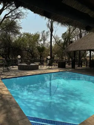 a large blue swimming pool in a resort at Halali Wilderness Private Game Ranch in Hammanskraal