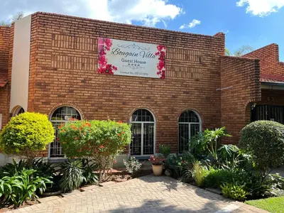 a brick building with a sign on it at Bougain Villa Guest House in Polokwane