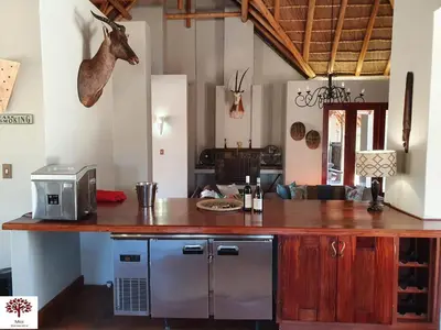 a kitchen with a counter with a microwave and a table at Zebula Golf and Wildlife Estate - Kudu's Bark Pax 12 - Moi Signature Luxury villa in Mabula