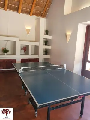 a ping pong table in the middle of a room at Zebula Golf and Wildlife Estate - Kudu's Bark Pax 12 - Moi Signature Luxury villa in Mabula