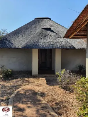 a building with a thatched roof and a walkway at Zebula Golf and Wildlife Estate - Kudu's Bark Pax 12 - Moi Signature Luxury villa in Mabula