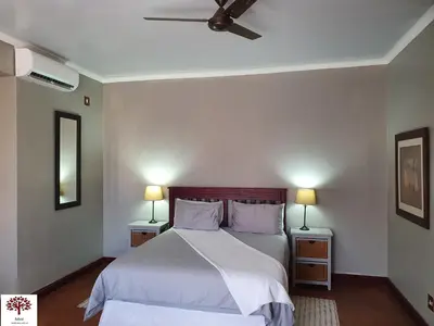 a bedroom with a bed with two night stands and two lamps at Zebula Golf and Wildlife Estate - Kudu's Bark Pax 12 - Moi Signature Luxury villa in Mabula