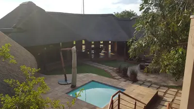 a small swimming pool in a yard with a house at Zebula Golf and Wildlife Estate - Giraffe Plains Pax 4 - Moi Signature Luxury villa in Mabula
