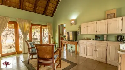 a kitchen with white cabinets and a table and chairs at Zebula Golf and Wildlife Estate - Walk of the Eland Pax 12 - Moi Signature Luxury villa in Mabula