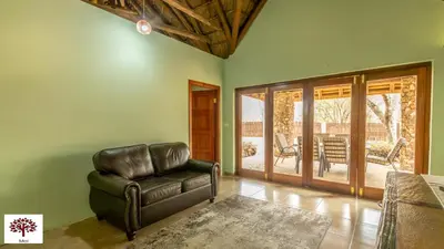 a leather chair in a living room with a patio at Zebula Golf and Wildlife Estate - Walk of the Eland Pax 12 - Moi Signature Luxury villa in Mabula